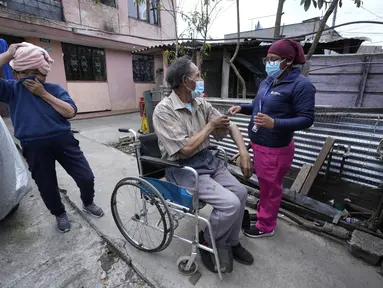 Seorang pria di kursi roda menyingsingkan lengan bajunya untuk vaksin COVID-19 di Quito, Ekuador, 26 Januari 2022. Brigade campuran dari pemerintah kota dan Kementerian Kesehatan mengunjungi lingkungan miskin untuk mendeteksi kasus COVID-19 dan melakukan vaksinasi. (AP Photo/Dolores Ochoa)