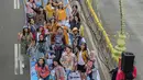 Sejumlah orang yang mengenakan batik berpose di catwalk Jalan Jenderal Sudirman, Jakarta, Minggu (2/10/2022). Kegiatan yang diikuti ratusan orang ini diselenggarakan oleh Bank Mandiri untuk menyambut Hari Batik Nasional yang jatuh setiap tanggal 2 Oktober 2022. (Liputan6.com/Faizal Fanani)