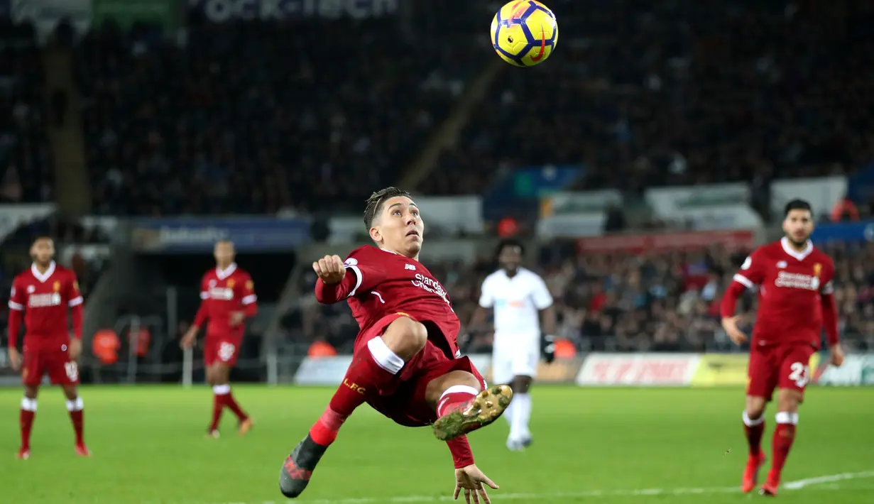 Pemain Liverpool, Roberto Firmino mengambil alih bola saat bertandang ke kandang Swansea City dalam lanjutan Premier League di Stadion Liberty, Selasa (23/1). Liverpool tumbang 0-1 dari penghuni dasar klasemen Liga Inggris Swansea. (Nick Potts/PA via AP)