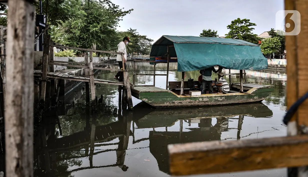 Warga bersiap menaiki perahu eretan untuk menyeberang di Kali Sunter, Rawa Badak, Jakarta, Rabu (20/1/2021). Kebanyakan penumpang adalah pedagang, pengunjung pasar, dan anak sekolah. (merdeka.com/Iqbal S. Nugroho)
