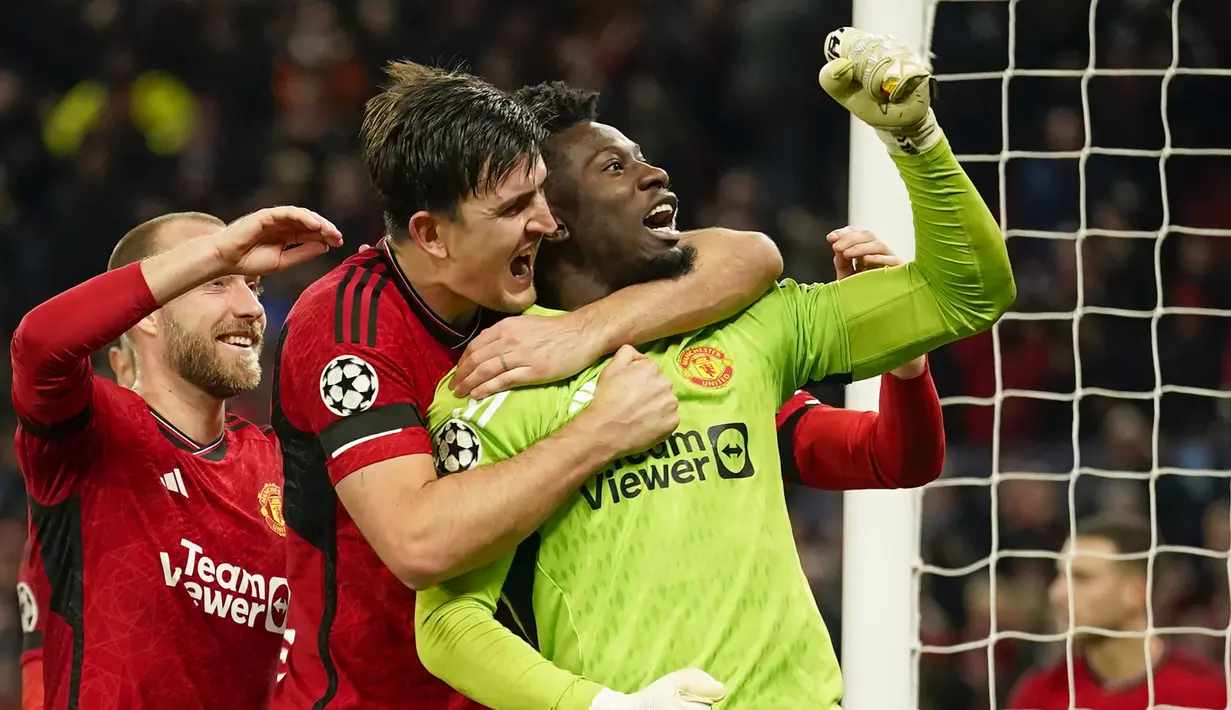 Selebrasi Kiper Manchester United, Andre Onana bersama rekannya, Harry Maguire setelah mementahkan eksekusi penalti striker  FC Copenhagen, Jordan Larsson pada laga matchday ketiga Grup A Liga Champions 2023/2024 di Old Trafford Stadium, Rabu (25/10/2023) dini hari WIB. (AP Photo/Dave Thompson)
