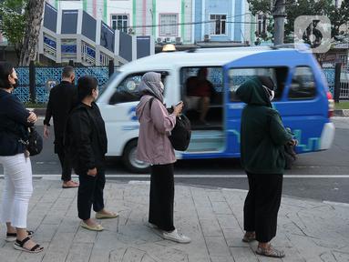 Para calon penumpang antre menunggu giliran untuk naik transportasi layanan angkutan umum JakLingko di Stasiun Klender Baru, Pondok Kopi, Jakarta, Senin (19/2/2024). (merdeka.com/Imam Buhori)