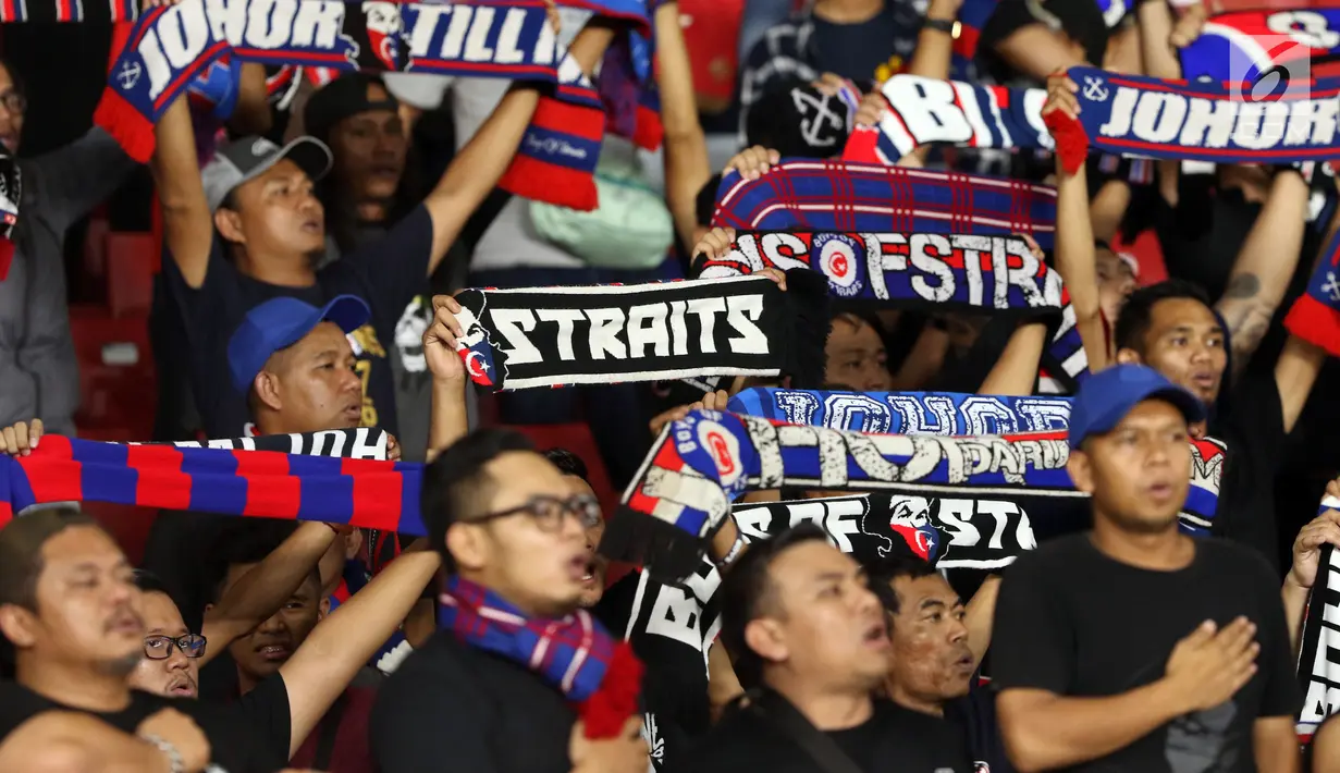 Suporter tim Johor Darul Takzim bernyanyi memberi semangat timnya saat melawan Persija pada lanjutan penyisihan Grup H Piala Asia 2018 di Stadion GBK, Jakarta, Selasa (10/4). Johor Darul Takzim kalah telak 0-4. (Liputan6.com/Helmi Fithriansyah)