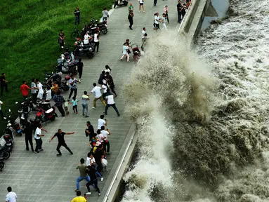 Gelombang air pasang menghantam penghalang di tepi Sungai Qiantang di Hangzhou, provinsi Zhejiang, Tiongkok, 4 Oktober 2016. Meski berbahaya, wisatawan gemar berkumpul untuk menyaksikan fenomena ini. (REUTERS)