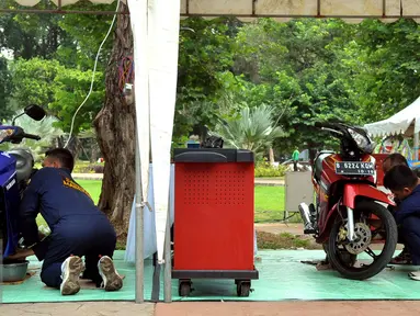 Sejumlah anggota TNI saat melakukan service sepeda motor gratis di kawasan Lapangan Banteng, Jakarta, Jumat (11/12). Kegiatan ini memperingati Hari Juang Kartika Tahun 2015 dan berlangsung sampai hari Minggu (13/12). (Liputan6.com/Faisal R Syam)