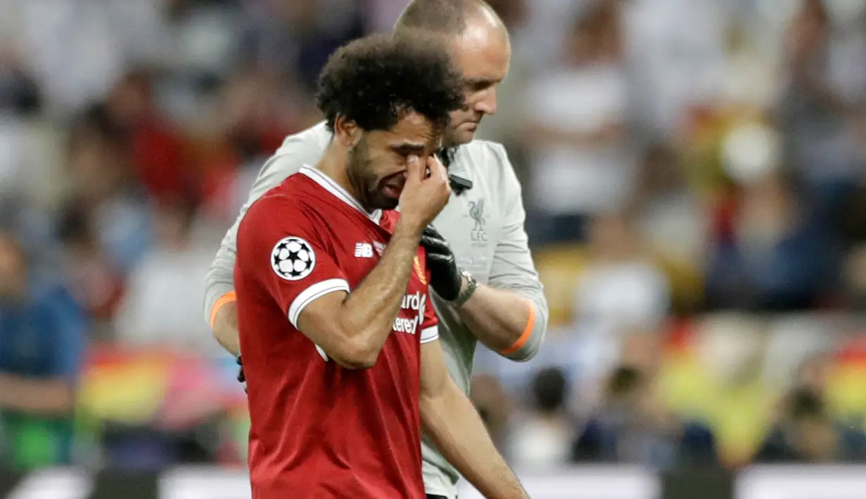 Pemain depan Liverpool Mohamed Salah meninggalkan lapangan sambil menangis usai cedera saat melawan Real Madrid dalam pertandingan final Liga Champions di Stadion NSK Olimpiyskiy, Ukraina (26/5). (AP / Matthias Schrader)