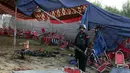 Seorang polisi Pakistan berjaga-jaga di lokasi serangan bom bunuh diri hari Minggu di distrik Bajur, Khyber Pakhtunkhwa, Pakistan, Senin, 31 Juli 2023. (AP Photo/Mohammad Sajjad)