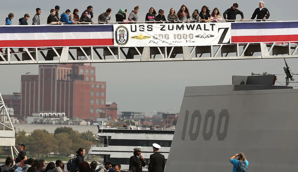 Pengunjung berada di Kapal USS Zumwalt di Baltimore, Maryland, AS (13/10). Kapal ini mampu berlabuh di perairan dangkal karena bentuknya yang ramping membuat Kapal USS Zumwalt akan terdeteksi sebagai kapal nelayan. (AFP Photo/Mark Wilson)