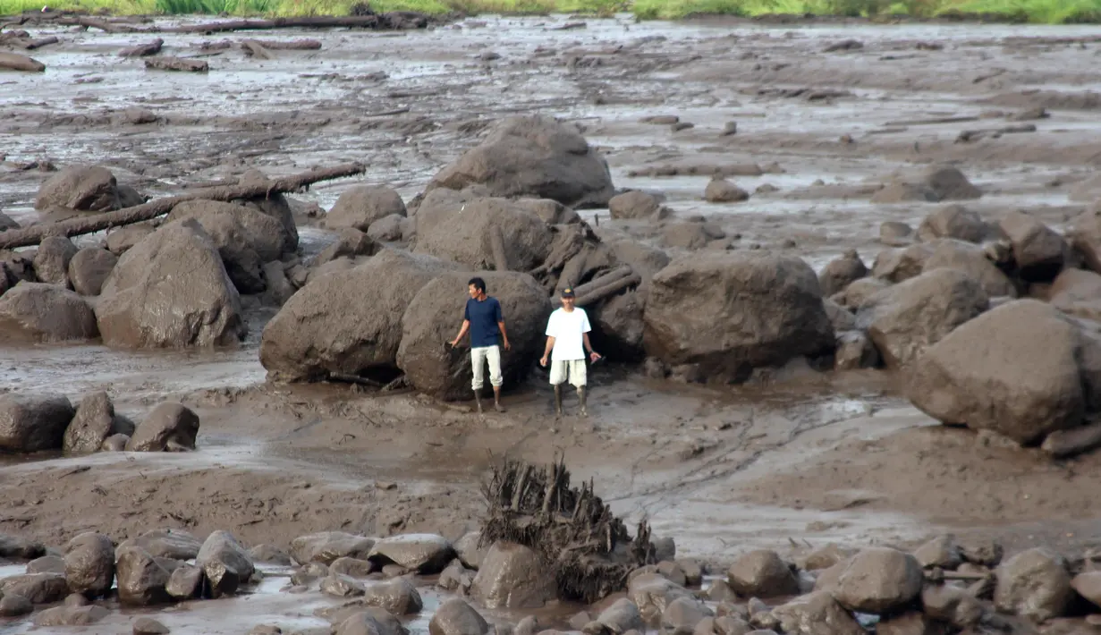 Orang-orang memeriksa daerah yang terkena dampak banjir bandang di Agam, Sumatra Barat, Indonesia, Minggu, 12 Mei 2024. (AP Photo/Ali Nayaka)