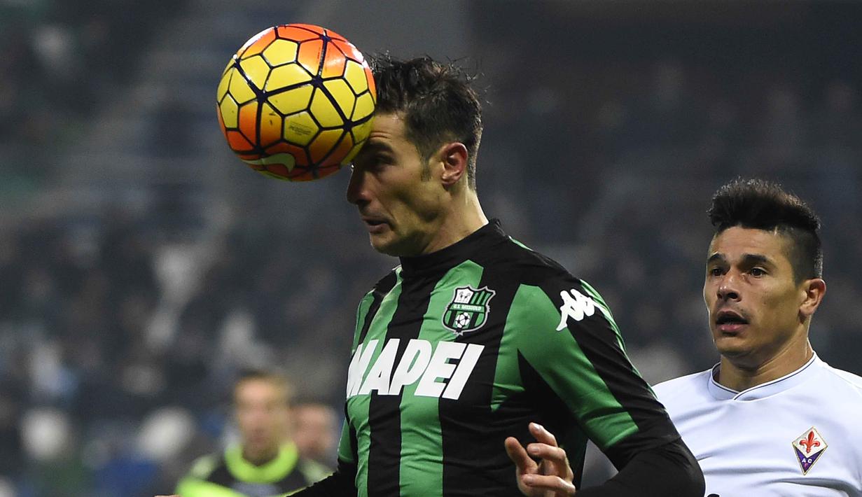 Pemain Sassuolo, Federico Peluso menyundul bola saat dibyangi pemain Fiorentina pada lanjutan liga Italia Serie A di Stadion Mapei, Reggio Emilia, Selasa (01/12/2015). (AFP Photo/Olivier Morin)