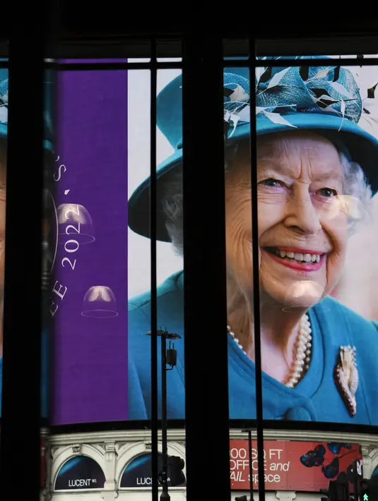 <p>Gambar Ratu Elizabeth II dari Inggris ditampilkan pada layar digital besar untuk menandai dimulainya Platinum Jubilee di Piccadilly Circus, 6 Februari 2022. Ratu Elizabeth II menjadi raja Inggris pertama yang memerintah selama tujuh dekade. (Daniel LEAL/AFP)</p>