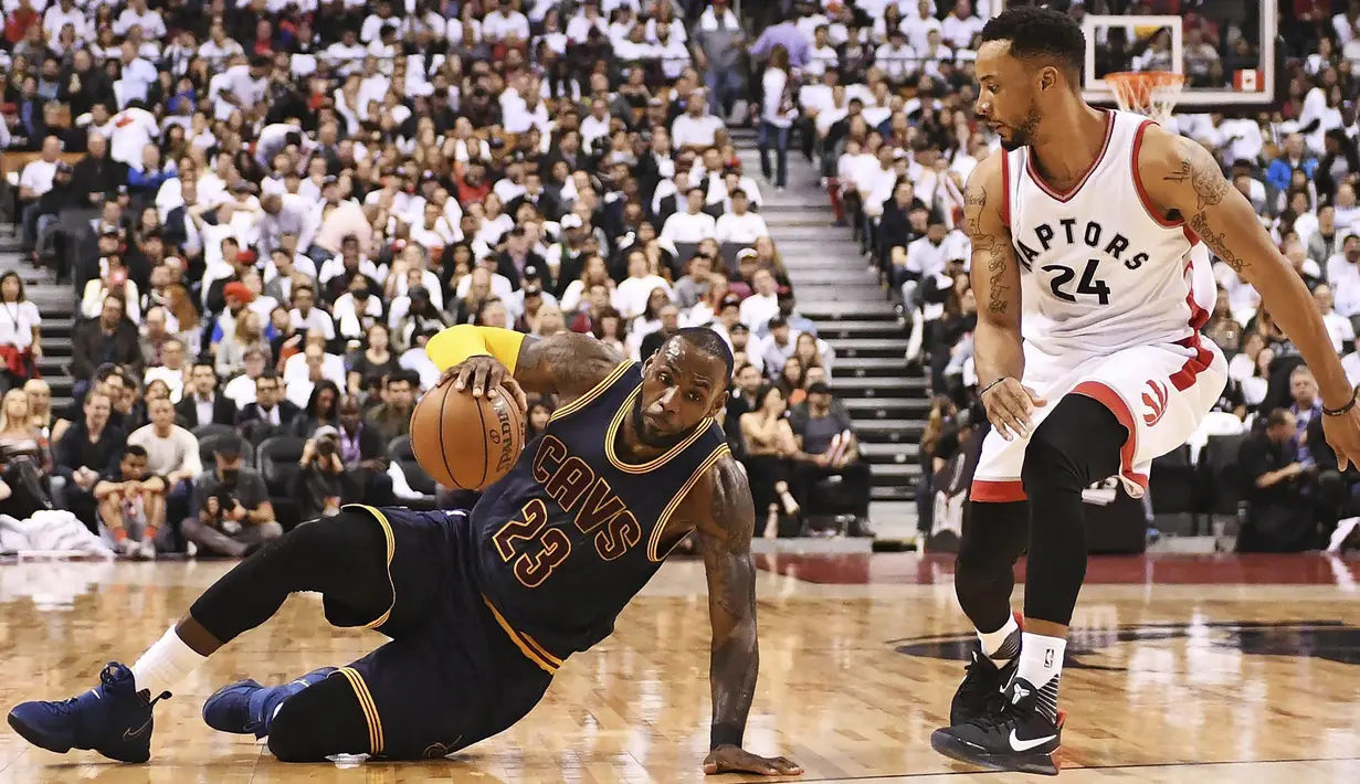 Pebasket Cleveland Cavaliers, LeBron James, berusaha melewati pebasket Toronto Raptors, Norman Powell pada laga Gim 3 semifinal Wilayah Timur di Air Canada Centre, Jumat (5/5/2017). Cleveland Cavaliers menang 115-94.(AP/Frank Gunn)