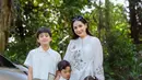 Nagita Slavina tampil dengan atasan putih model tali samping dihiasi bordiran bunga. Tampilannya kompak dengan ketiga anaknya. [@raffinagita1717]