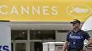 Seorang polisi Prancis berdiri di depan Festival Palace pada malam pembukaan Festival Film Cannes ke-69, Selasa (10/5). Ketatnya penjagaan dilakukan mengingat Prancis masih dalam kondisi waspada akibat berisiko tinggi terhadap serangan. (Loic VENANCE/AFP)