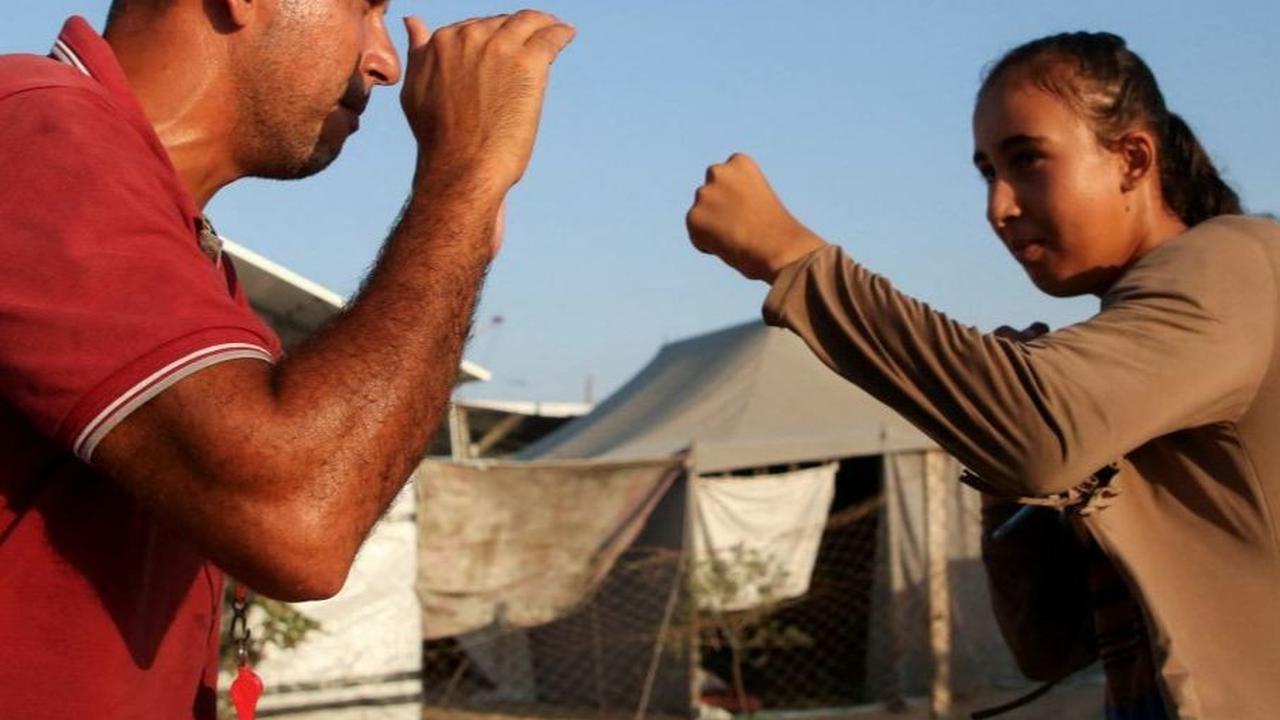 Di tempat yang penuh dengan kesedihan, pelatih tinju Palestina, Osama Ayoub, berdedikasi untuk memberikan semangat dan harapan kepada para gadis muda Palestina melalui olahraga tinju. Foto: REUTERS / Hatem Khaled<br>