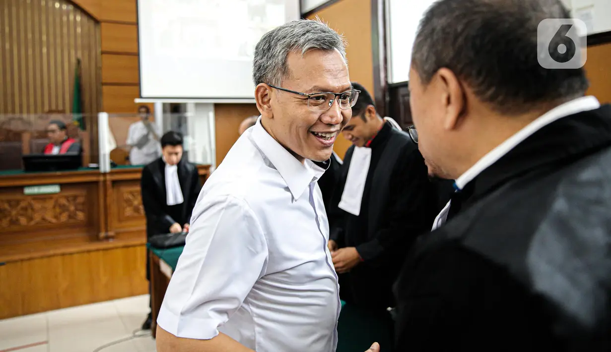 Terdakwa Agus Nurpatria tersenyum saat berjabat tangan dengan kuasa hukum usai menjalani sidang perdana di PN Jakarta Rabu (19/10/2022). Agus Nurpatria menyalami kuasa hukum dengan penuh senyuman usai menjalani sidang dengan agenda pembacaan surat dakwaan kasus obstruction of justice atau perintangan proses penyidikan terkait perkara dugaan pembunuhan berencana terhadap Nofriansyah Yosua Hutabarat atau Brigadir J. (Liputan6.com/Faizal Fanani)