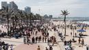 Ribuan wisatawan bersuka ria saat perayaan Tahun Baru di North Beach, Durban, Afrika Selatan, 1 Januari 2022. Pemerintah Afrika Selatan mencabut pembatasan COVID-19 dengan menghapus jam malam dari tengah malam hingga pukul 04.00. (Rajesh JANTILAL/AFP)