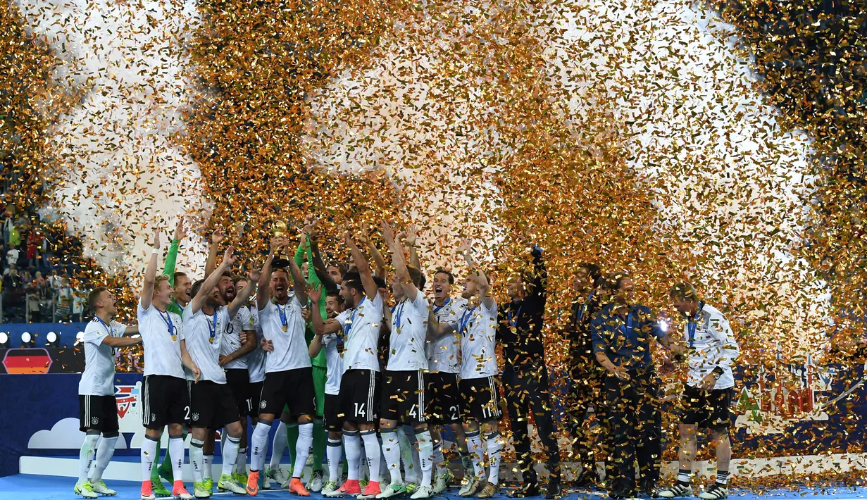 Pemain Jerman mengangkat trofi saat merayakan kemenangannya dalam final Piala Konfederasi 2017 di Stadion Saint Petersburg, Rusia (2/7). Gol tunggal tersebut berhasil dicetak oleh pemain Jerman, Lars Stindl. (AFP Photo/Patrik Stollarz)
