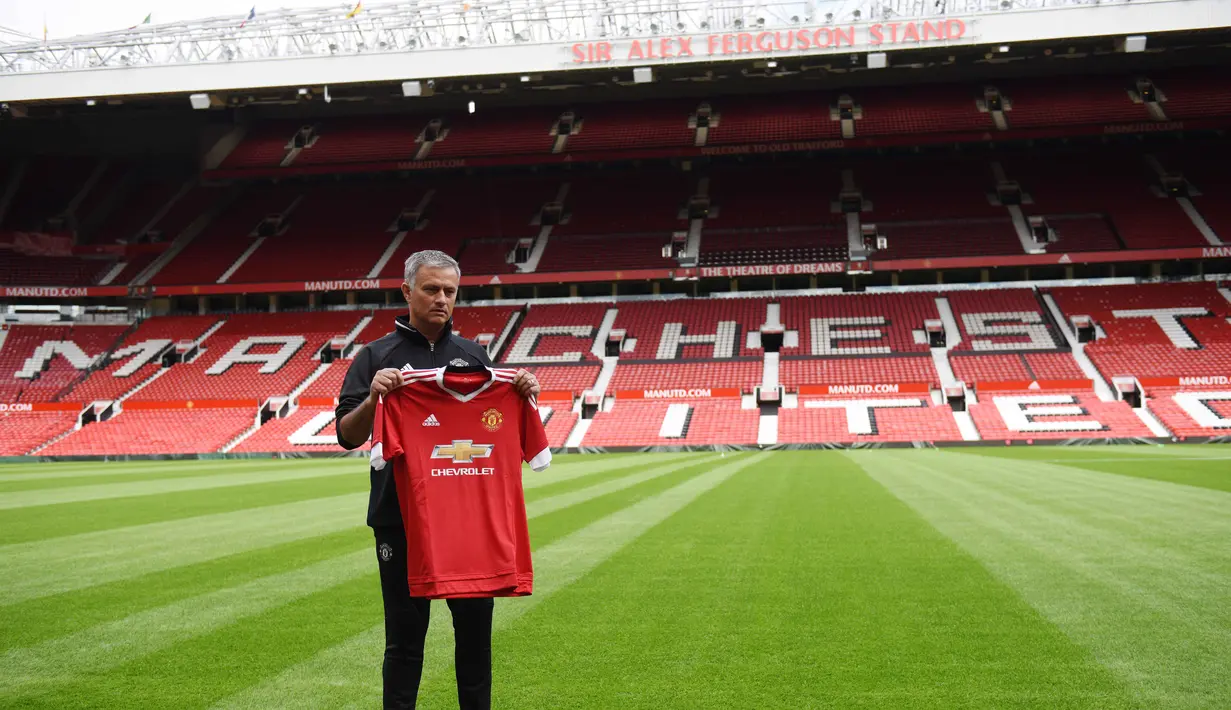 ose Mourinho berfoto dengan jersey Manchester United saat perkenalan di Stadion Old Trafford, Manchester, (5/7/2016). (AFP/Oli Scarff)