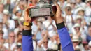 Petenis Spanyol, Rafael Nadal mengangkat trofinya setelah mengalahkan Stan Wawrinka pada final Prancis Terbuka di Roland Garros, Minggu (11/6). Nadal unggul dengan skor 6-2, 6-3, 6-1 untuk meraih gelar kesepuluh atau La Decima. (AP Photo/Michel Euler)