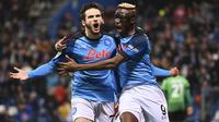 Selebrasi striker Napoli Khvicha Kvaratskhelia (kiri) bersama rekannya, Victor Osimhen setelah mencetak gol ke gawang Sassuolo pada laga Liga Italia 2022/2023 di Reggio Emilia Stadium, (17/2/2023). Khvicha Kvaratskhelia yang baru berusia 22 tahun kini mempunyai nilai pasar sebesar 60 juta euro atau setara Rp968 miliar. (LaPresse via AP Photo/Massimo Paolone)