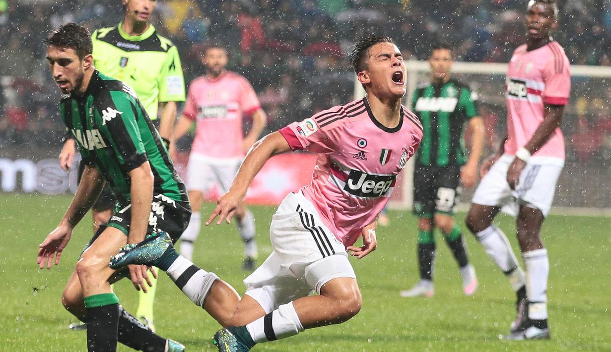 Pemain Juventus, Paulo Dybala terjatuh saat berebut bola dengan pemain Sassuolo, Sime Vrsaljko pada laga Serie A di Stadion Mapei, Italia, Rabu (28/10/2015). (EPA/Serena Campanini)