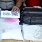 Petugas menunjukan barang bukti jenis shabu saat merilis barang bukti di Polsek Senen, Jakarta, Senin (6/4/2015). Polisi berhasil mengamankan 2 kg shabu dari warga kenegaraan Iran, Hajinasiri Mohsen Aliasgharr. (Liputan6.com/Johan Tallo)