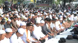 Massa pendukung pasangan capres-cawapres Prabowo Subianto dan Sandiaga Uno melakukan salat asar di Jalan Medan Merdeka Barat, Jakarta, Kamis (27/6/2019). Aksi tersebut dilakukan jelang putusan perselisihan hasil pemilihan umum (PHPU) Pilpres 2019 di Gedung MK. (merdeka.com/Arie Basuki)