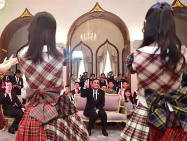 Perdana Menteri Thailand, Prayut Chan-O-Cha menyaksikan grup musik Jepang, AKB48, tampil di Gedung Pemerintahan, Kamis (13/8). Kunjungan ini adalah promosi AKB48 untuk mempersiapkan konser di Bangkok pada Desember mendatang. (HO/ROYAL THAI GOVERNMENT/AFP)