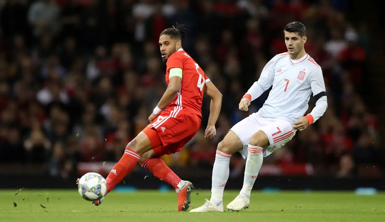 Pemain Wales, Ashley Williams berebut bola dengan striker Spanyol, Alvaro Morata saat bertanding pada uji coba internasional di Stadion Principality, Cardiff, Inggris (11/10). Spanyol menang telak 4-1 atas Wales. (AP Photo/Nick Potts)
