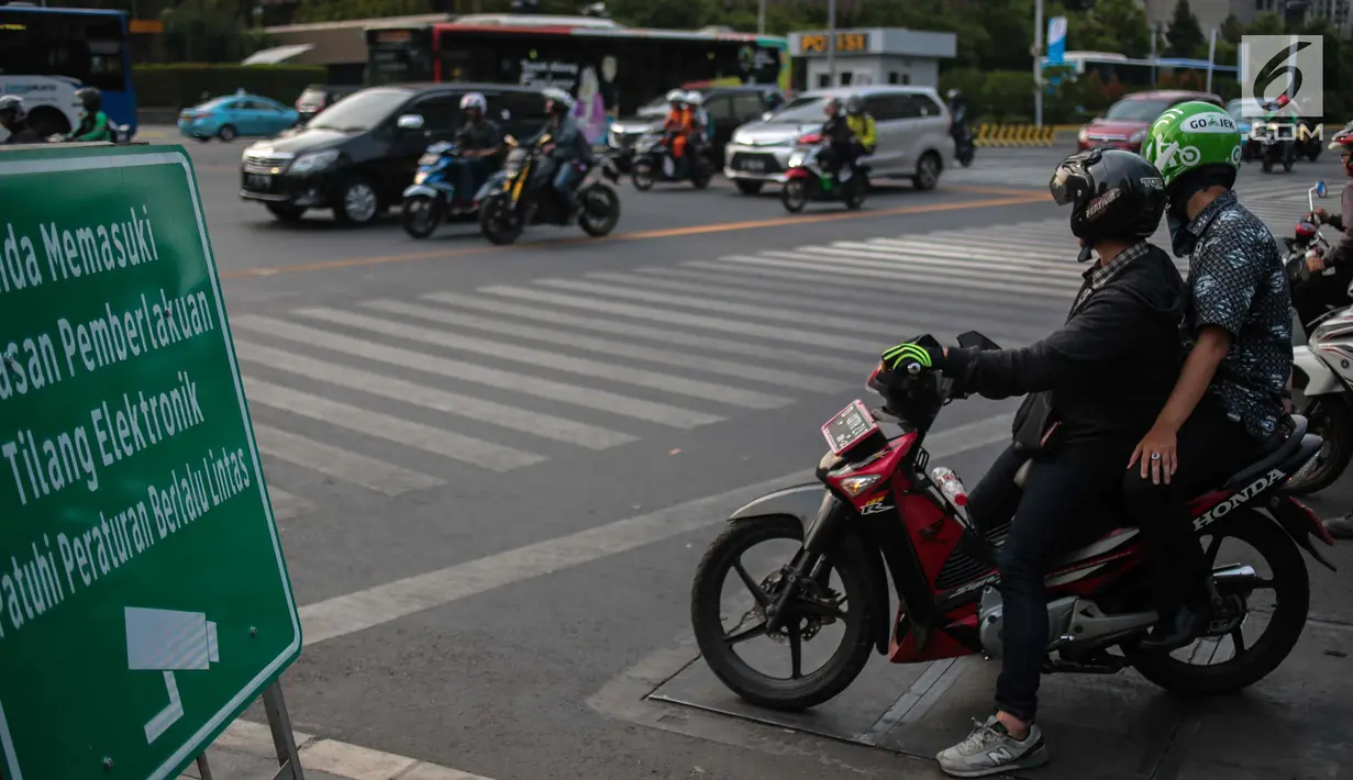 Pengendara sepeda motor berhenti di lampu merah Jalan MH Thamrin, Jakarta, Kamis (4/10). Uji coba tilang elektronik di DKI Jakarta berhasil menjaring ratusan pelanggar pada hari pertama dan kedua. (Liputan6.com/Faizal Fanani)