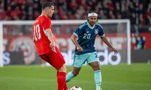 Granit Xhaka menghadapi Serge Gnabry dalam laga uji coba internasional antara Swiss vs Jerman di St. Jakob-Park, 28 Maret 2026. (Georgios Kefalas/Keystone via AP)