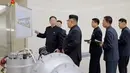 Kim Jong-un berbincang dengan para peneliti saat meninjau pembuatan bom hidrogen pada 3 September 2017. Bom ini diklaim berkekuatan hingga ratusan kiloton ini dibuat dengan berbagai komponen produksi dalam negeri. (KRT via AP Video)