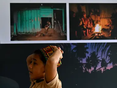Pengunjung melihat karya pameran foto jurnalistik Prahara Pulau Emas di Museum Tsunami Aceh, Banda Aceh, Aceh, Sabtu, 8 Agustus 2026. (AFP/ Chaideer Mahyuddin)