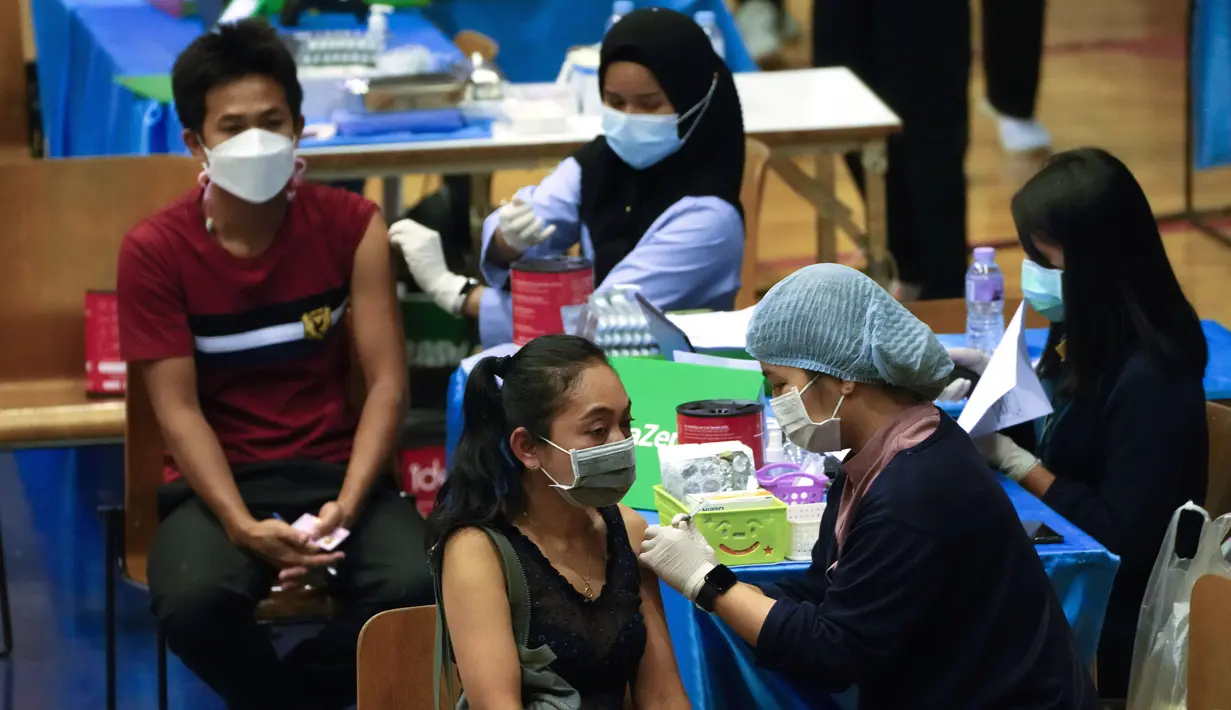 Petugas memberikan vaksin COVID-19 AstraZeneca kepada seorang perempuan di Bangkok, Thailand, 23 Februari 2022. Mulai 1 Maret, turis asing yang telah divaksin penuh hanya diminta menjalani satu kali tes PCR setelah kedatangan dan tes antigen mandiri setelah lima hari. (AP Photo/Sakchai Lalit)