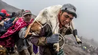 Suku Tengger membawa kambing sajen menuju puncak untuk melarungnya ke kawah dalam ritual Yadnya Kasada di Gunung Bromo, Probolinggo, Jawa Timur, Kamis (18/7/2019). Ritual Yadnya Kasada adalah upacara adat umat Hindu suku Tengger yang diselenggarakan setiap tahun. (JUNI KRISWANTO/AFP)