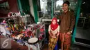 PKL wanita dan pria berpose di emperan toko kawasan Malioboro mengenakan pakaian tradisional, Rabu (20/4/2016). Sejumlah PKL mengenakan pakain adat jawa menyambut hari Kartini 21 April besuk. (Liputan6.com/Boy Harjanto)