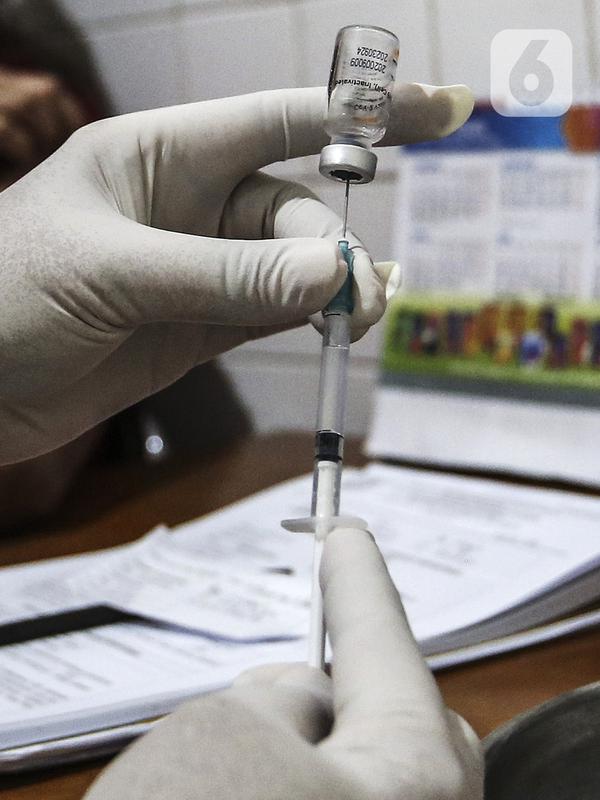 Petugas medis menyedot vaksin COVID-19 Sinovac untuk disuntikkan kepada tenaga kesehatan di Puskesmas Palmerah, Jakarta, Kamis (28/1/2021). Pemberian vaksin COVID-19 tahap kedua dilaksanakan terhadap tenaga kesehatan mulai hari ini. (Liputan6.com/Johan Tallo)