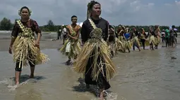 Penduduk dari Suku Mah Meri berjalan menuju laut selama ritual Puja Pantai di Pulau Carey, Kuala Lumpur, 9 Februari 2019. Puja Pantai merupakan ritual persembahan kepada roh laut yang digelar untuk merayakan tahun baru Suku Mah Meri. (Mohd RASFAN/AFP)