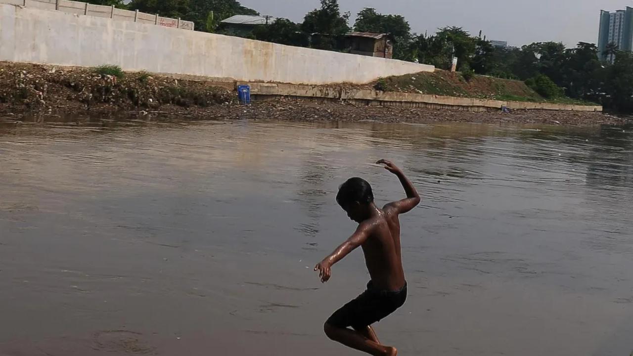 Sejumlah anak kembali dengan keceriaannya bermain di aliran kali Ciliwung yang sudah kembali dipenuhi air di kawasan Cawang, Jakarta, Kamis (16/11/2023). Sebelum kali ini nyaris kering akibat musim kemarau bulan lalu.<br>