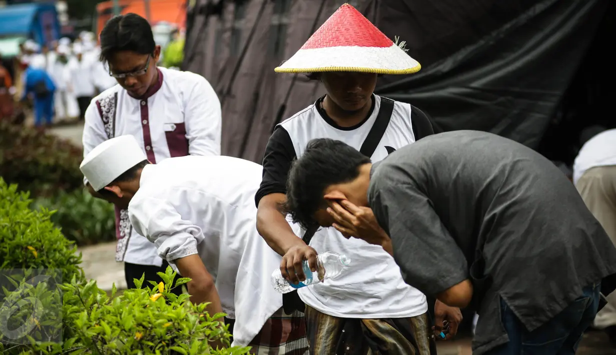 Peserta aksi damai 212 mengambil air wudhu dengan botol air minum untuk berwudhu di Monas, Jakarta, Jumat (2/12). Dikarenakan penuhnya tempat wudhu yang telah disediakan Peserta mengambil wudhu dengan botol air minum. (Liputan6.com/Faizal Fanani)