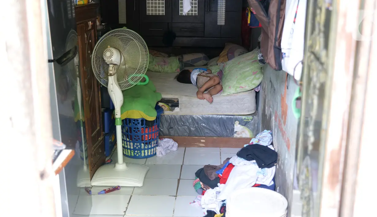 Seorang anak tidur di dalam rumahnya di Gang Sekretaris, RT 015/RW 007 Tanjung Duren Utara, Jakarta Barat , Selasa (8/10/2019). Warga di kawasan ini tak memiliki septic tank sehingga hajat yang dibuang langsung mengalir ke kali yang bersebelahan dengan tempat tinggal. (Liputan6.com/Herman Zakharia)