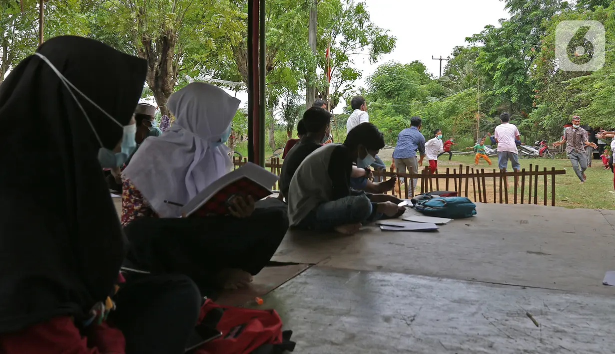 Murid-murid melihat temannya bermain tap benteng di sekolah alam Sukawangi, Kabuapaten Bekasi, Jawa Barat, Senin (30/11/2020). Kegiatan bermain di alam terbuka menjadi solusi bagi para murid untuk menghilangkan rasa jenuh usai belajar dimasa pandemi COVID-19. (Liputan6.com/Herman Zakharia)