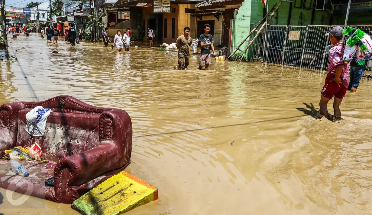 Sejumlah warga melintasi banjir yang merendam komplek Pondok Gede Permai, Jatiasih, Bekasi, Jumat (22/4). Banjir yang sempat mencapai 4 meter di perumahan tersebut merendam lebih dari 500 rumah yang dihuni ribuan warga. (Liputan6.com/Fery Pradolo)