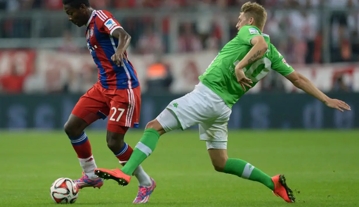 Gelandang Vfl Wolfsburg, Aaron Hunt (kanan), berusaha menjegal pergerakan pemain belakang Bayern Munich, David Alaba, saat berlaga dilanjutan Bundesliga di Allianz Arena, (23/8/2014). (AFP PHOTO/Christof Stache)