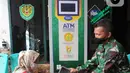 Warga menggunakan ATM Pertanian Si Komandan untuk mendapatkan beras gratis di Kodim 0606/Kota Bogor, Jawa Barat, Minggu (26/4/2020). Kementerian Pertanian bersama Bank BNI, dan TNI AD  menempatkan ATM beras gratis di sejumlah Kodim di wilayah Jabodetabek. (merdeka.com/Arie Basuki)
