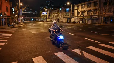 Seorang pria mengendarai skuter di jalan sebelum dimulainya lockdown tahap kedua sebagai tindakan pencegahan terhadap virus corona COVID-19 di Shanghai, China, 31 Maret 2022. (Hector RETAMAL/AFP)
