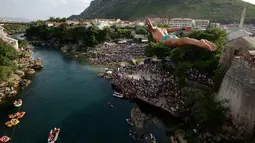 Peserta melompat dari Jembatan Old Mostar pada kompetisi menyelam tradisional ke-452 di Mostar, Bosnia, 29 Juli 2018. Penyelam berlari sebelum melompat dari jembatan, jatuh ke sungai dan terbang di udara seperti burung melakukan trik. (AP/Amel Emric)