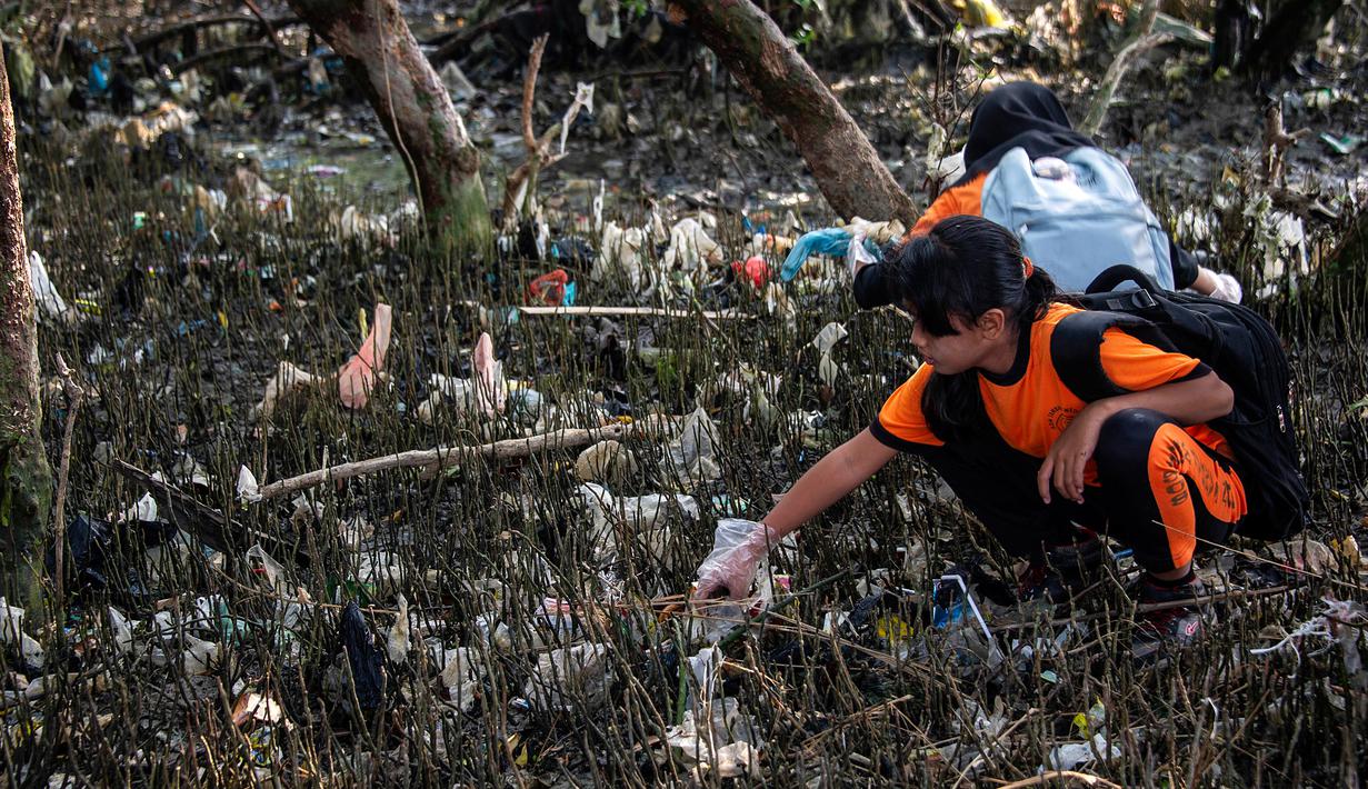 Seorang anak membersihkan sampah pada kegiatan World Cleanup Day 2019  di kawasan pantai di Surabaya, Sabtu (21/9/2019). Aksi bersih-bersih sampah yang digelar secara serentak di 157 negara ini mengajak masyarakat untuk bijak menggunakan plastik.  (JUNI KRISWANTO / AFP)