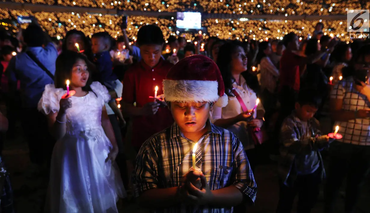 Anak-anak memegang lilin pada perayaan Natal Tiberias Indonesia yang ke-17 di Stadion GBK, Senayan, Jakarta, Sabtu (8/12). Puluhan ribu jemaat dari 14 provinsi menghadiri perayaan natal. (Liputan6.com/Johan Tallo)